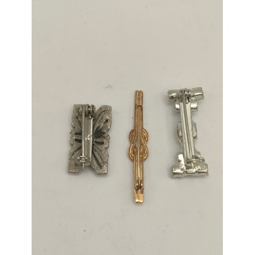 188 - Three brooches to include a love infinity knot, white metal pin brooch.
Location: CAB1