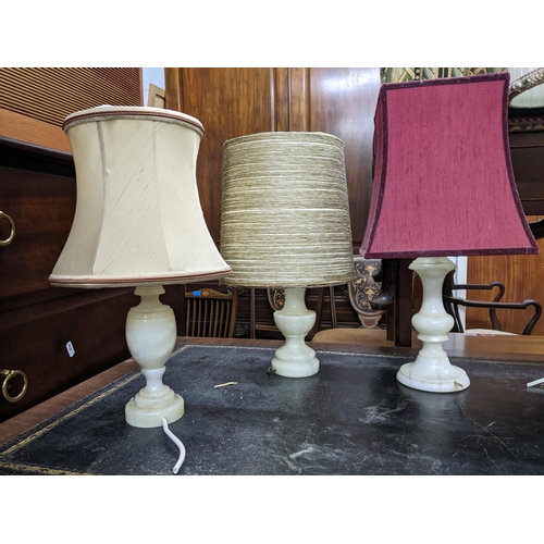 195 - A selection of lamps to include a pair of white onyx and gilt metal lamps with fabric shades, three ... 