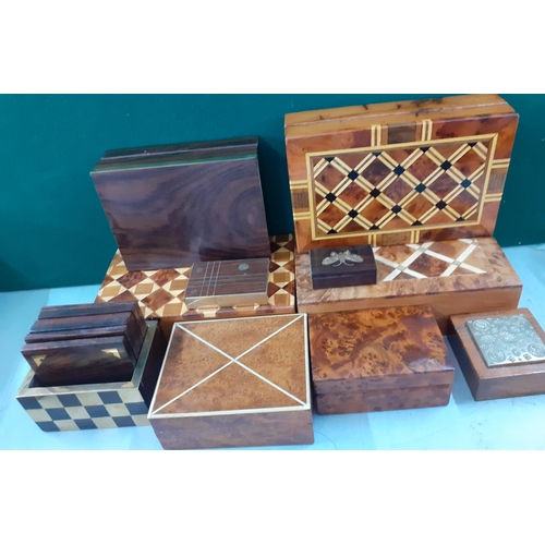 95 - A group of walnut and parquetry cigarette and other boxes together with treen drinks mats and other ... 