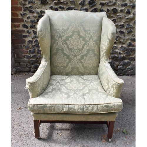 420 - A George III mahogany wingback armchair, early 19th century, upholstered in green brocade, on straig... 