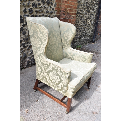 420 - A George III mahogany wingback armchair, early 19th century, upholstered in green brocade, on straig... 