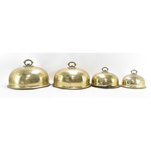 422 - A graduated set of Victorian brass meat covers, with beaded rim and hoop handles, the front of each ... 