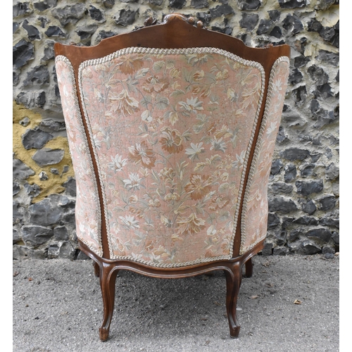 426 - A Louis XV style bergère armchair, with carved walnut frame with central rocaille motif, upholstered... 