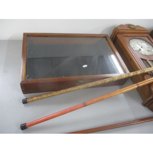 111 - Two 8 day wall hanging clocks together with a display table top cabinet and three walking sticks, on... 