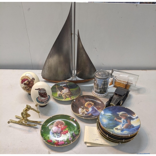 124 - A mixed lot to include a metal sailing boat, two tribal eggs, a brass figurine, collector's plates a... 