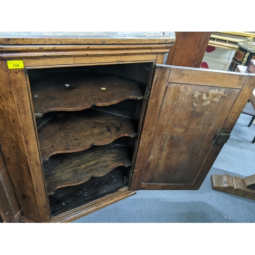 158 - A Georgian oak wall hanging corner cabinet having a panelled door and stepped cornice 93cm h x 73.5c... 