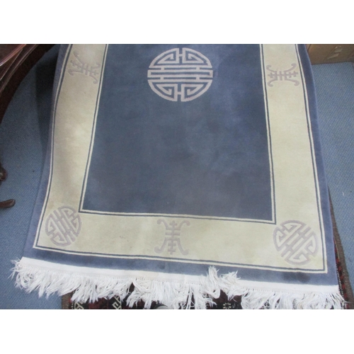 25 - A Chinese blue ground rug decorated with motifs and having a cream border, 188cm x 122cm
Location: L... 