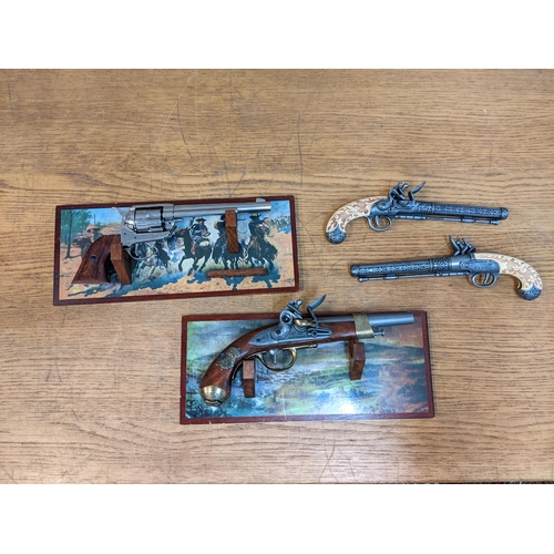 339 - Four reproduction pistols comprising a pair of duelling flintlock style pistols, a French Napoleon f... 