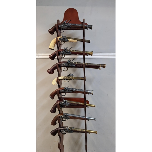 340 - Nine reproduction flintlock style pistols with ornate decoration on a stand
Location: G