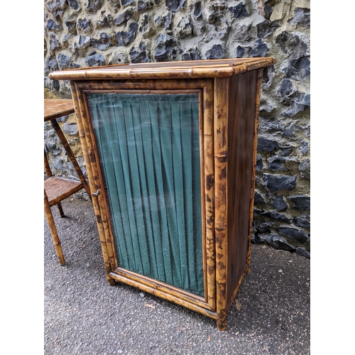 344 - A Victorian bamboo cabinet with glazed and curtained door internal shelves, on short feet, 80x54x36.... 