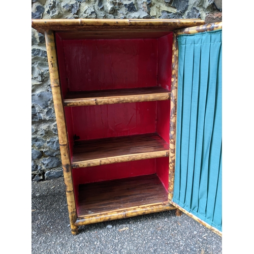 344 - A Victorian bamboo cabinet with glazed and curtained door internal shelves, on short feet, 80x54x36.... 