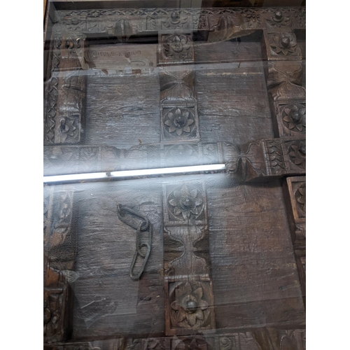 354 - A Large Asian carved wooden door panel coffee table, the carved door panel ornately worked, with wro... 