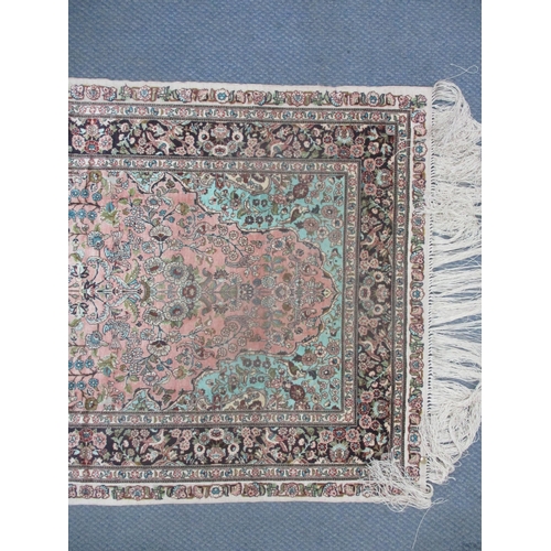 7 - A Persian silk hand woven rug having a pink ground decorated with birds amongst a floral design and ... 