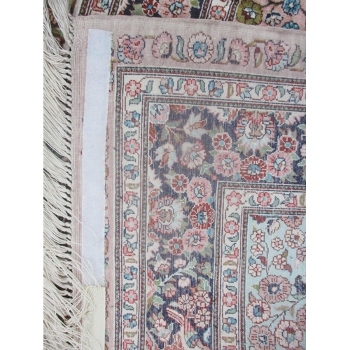 7 - A Persian silk hand woven rug having a pink ground decorated with birds amongst a floral design and ... 