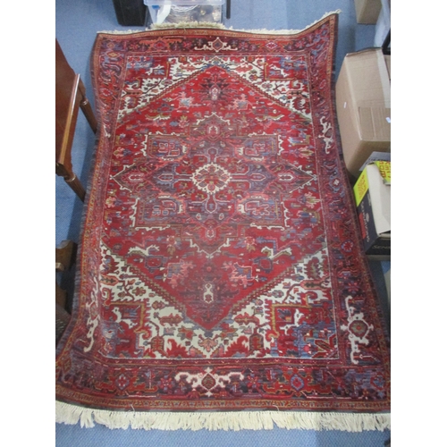 23 - A machine woven Kadjar rug having a red ground, central motif and tasselled ends 140cm x 197cm Locat... 