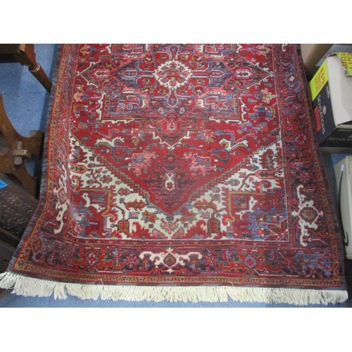 23 - A machine woven Kadjar rug having a red ground, central motif and tasselled ends 140cm x 197cm Locat... 