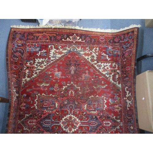 23 - A machine woven Kadjar rug having a red ground, central motif and tasselled ends 140cm x 197cm Locat... 