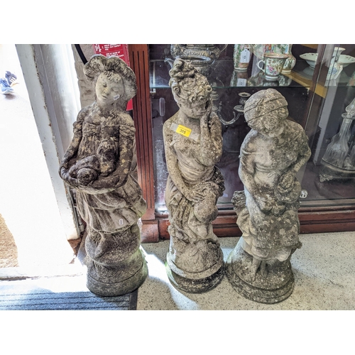 305 - A group of three weathered concrete garden statues depicting maidens in various poses, the tallest 6... 