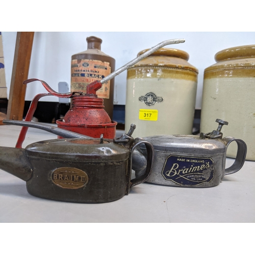 317 - Motoring memorabilia to include three oil cans, one unbranded and two branded Braimes/Braime, a Wait... 