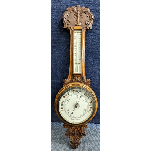 319 - An early 20th century wall hanging Aneroid barometer in an oak carved case, 86cm h 
Location:RAB