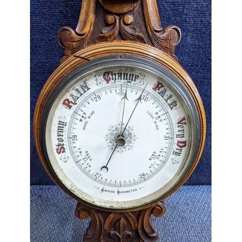 319 - An early 20th century wall hanging Aneroid barometer in an oak carved case, 86cm h 
Location:RAB