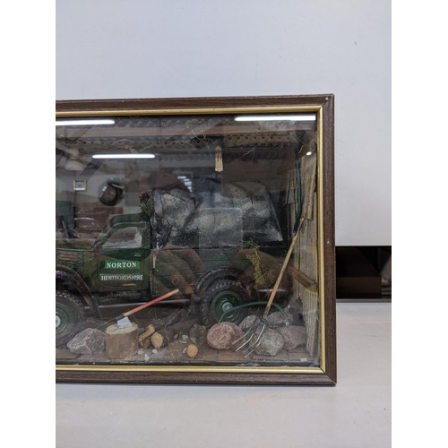 322 - A model garage scene in a glazed case depicting a Norton truck surrounded by tools and equipment in ... 