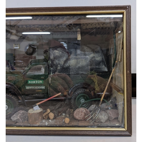 322 - A model garage scene in a glazed case depicting a Norton truck surrounded by tools and equipment in ... 