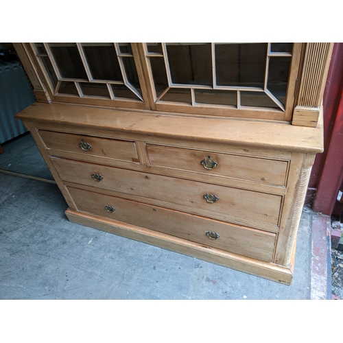 461 - A 19th century pine bookcase having a moulded cornice, twin glazed doors above two short and two lon... 