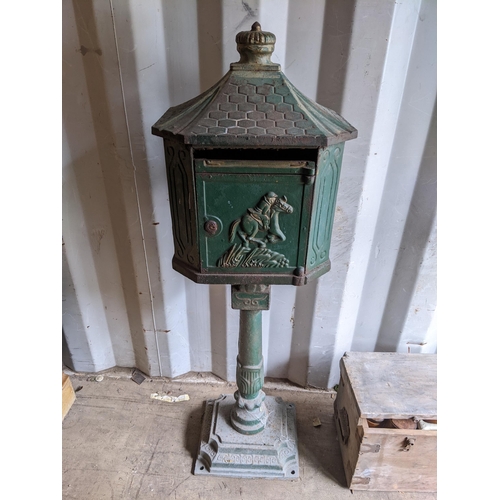 471 - A late Victorian cast iron green painted letter box, the door relief decorated with a figure on hors... 