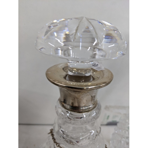 485 - A pair of crystal cut decanters having silver rims, along with two silver decanter labels Location: ... 