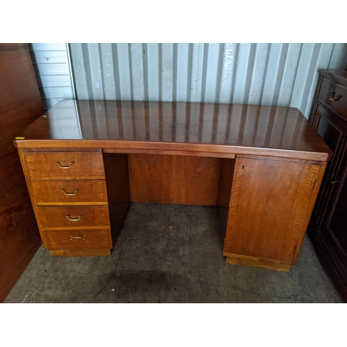 487 - An early/mid 20th century walnut twin pedestal desk having four drawers and single cupboard door, 76... 