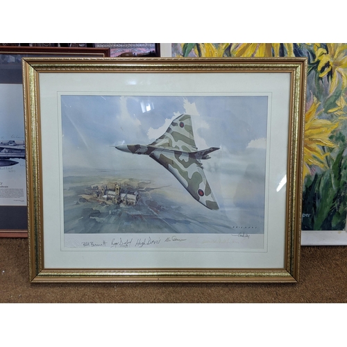 491 - Two aeroplane prints, one of a Vulcan flying over the countryside, bears signatures and a blindstamp... 