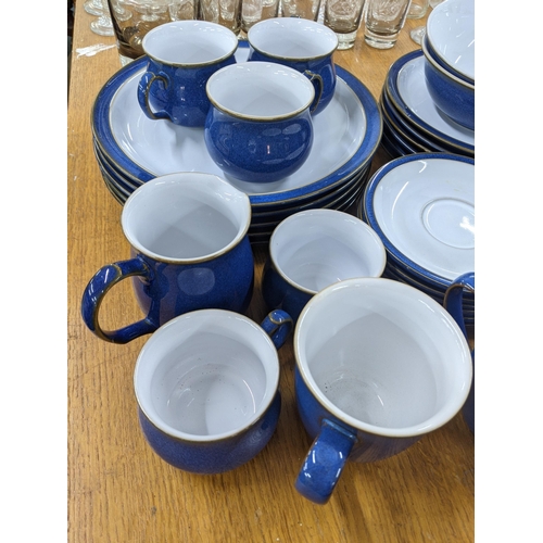 501 - A Denby blue part dinner service to include dinner and side plates, desert bowls, a milk jug, sugar ... 