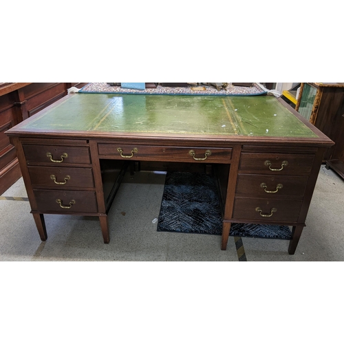 508 - A mid 20th century mahogany twin pedestal writing desk having a green leather topped scriber and sev... 