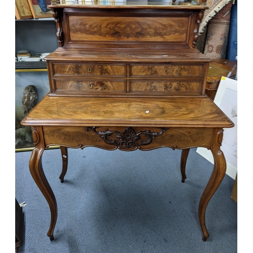 512 - A 19th century French mahogany bonheur du jour having a brass gallery top above four short, lone lon... 