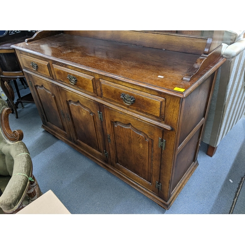 541 - A reproduction oak dresser having three glazed doors above three drawers and three cupboard doors 18... 