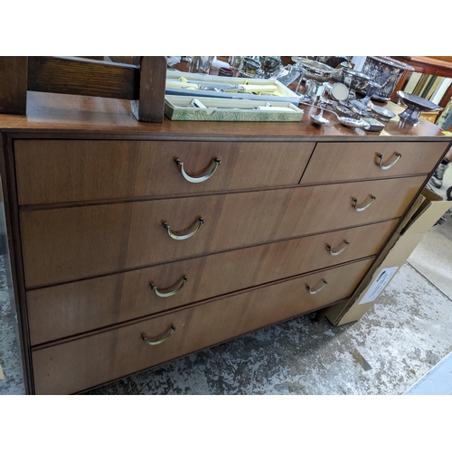 545 - A mid-century teak dressing chest of two short above three long drawers, on short tapering legs and ... 