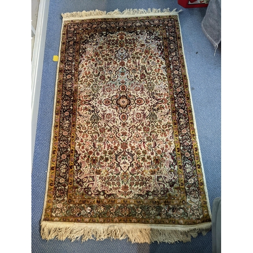 66 - A handwoven Indian design rug with a central motif and decorated with flowers and foliage on a cream... 