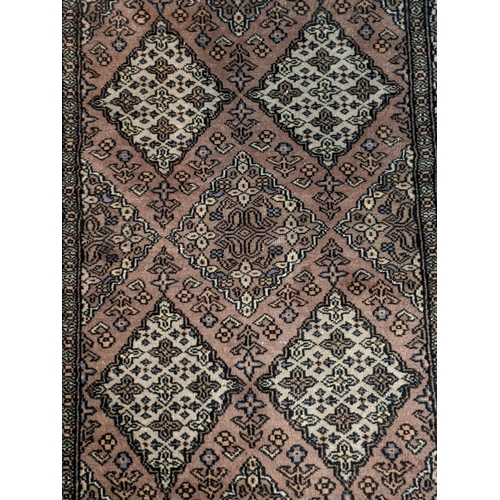 67 - A handwoven Persian design rug with repeating gulls decorated with a repeating geometric floral bord... 