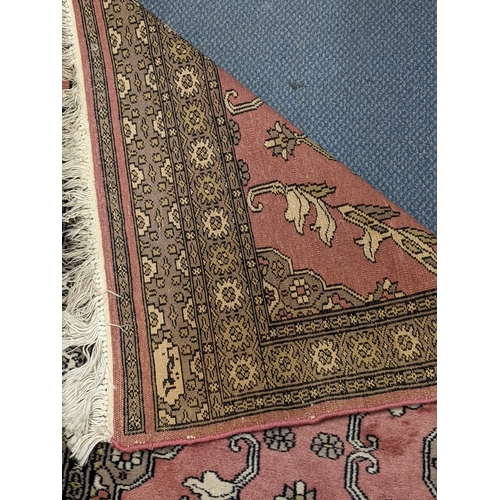 70 - A handwoven Turkish runner with four repeating motifs decorated with foliage on a mottled pink backg... 