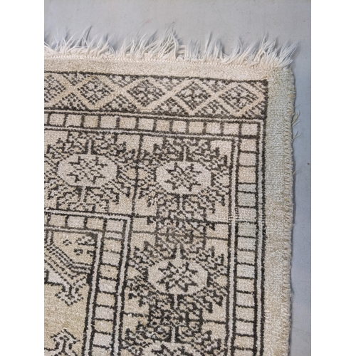 71 - A handwoven Persian design silk rug, the geometric design with four motifs on a cream background 98c... 