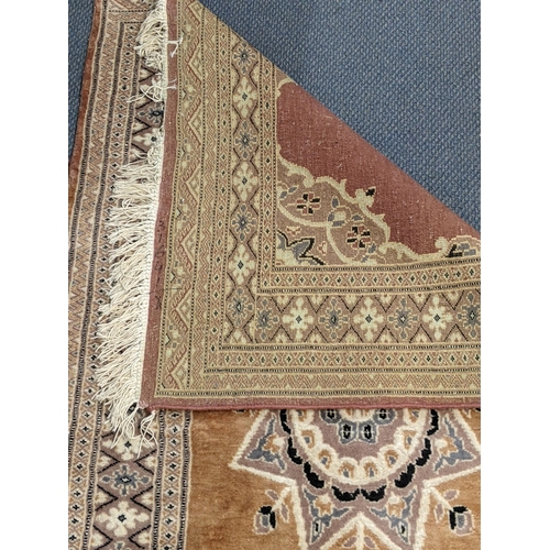 72 - A handwoven Turkish design Oushak rug with a central symmetrical motif and a repeating border on a l... 