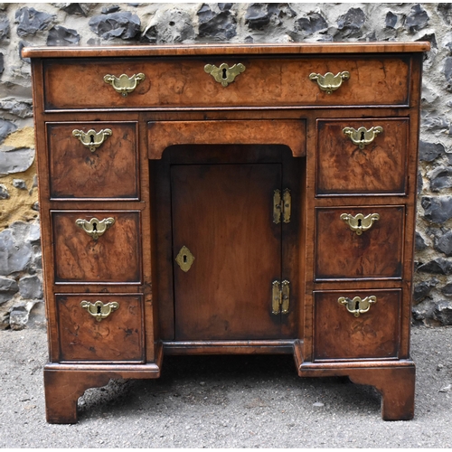 123 - An early George III burr walnut and feather-banded kneehole desk, the bookmatched veneer top with he... 