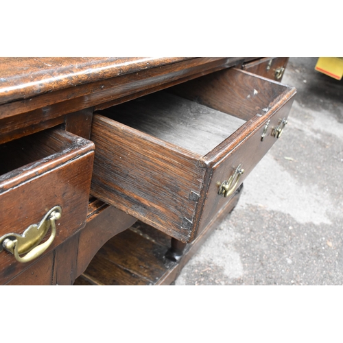 125 - A George III oak open potboard dresser, in two sections, designed with moulded cornice above three s... 