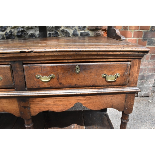 125 - A George III oak open potboard dresser, in two sections, designed with moulded cornice above three s... 