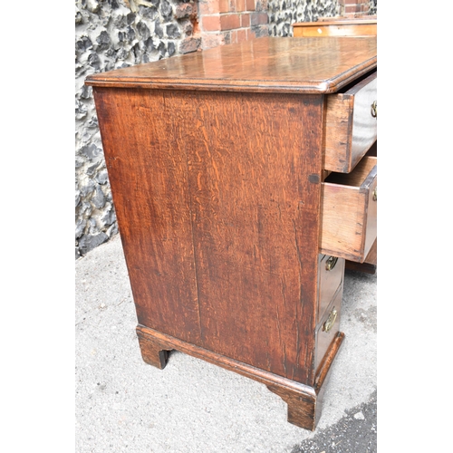 135 - An early George III walnut and feather-banded kneehole desk, the bookmatched veneer top with herring... 