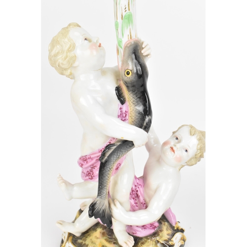 152 - Two Meissen figural candlesticks, 19th century, each modelled as two putti supporting a fish issuing... 