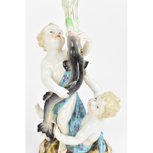 152 - Two Meissen figural candlesticks, 19th century, each modelled as two putti supporting a fish issuing... 