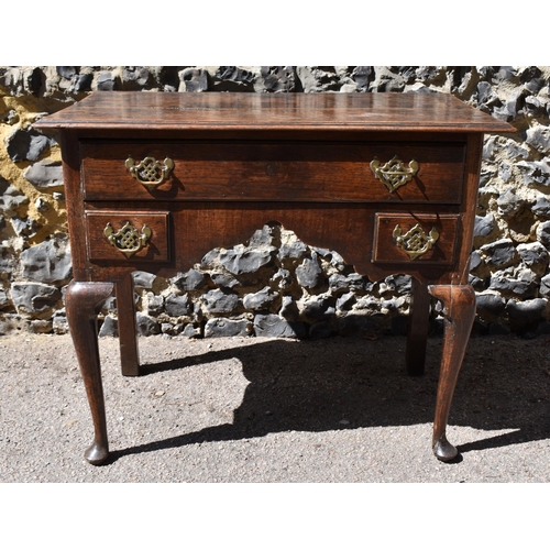 138 - A George III oak kneehole dressing table, with frieze drawer above two small dummy drawers, on cabri... 