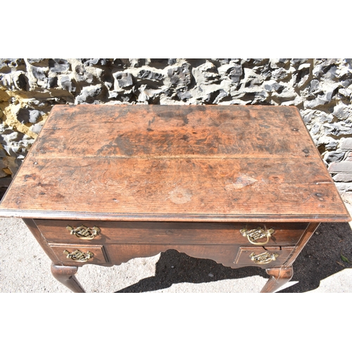 138 - A George III oak kneehole dressing table, with frieze drawer above two small dummy drawers, on cabri... 